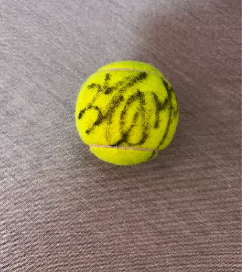 出三个球星签名网球。有两个张帅的,一个韩馨...