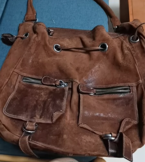 一个很旧的甚至有的地方已经破了的一个真皮包...