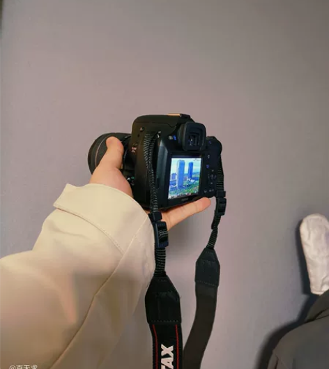 出黑色的宾得相机，型号为K50，是单反相机...