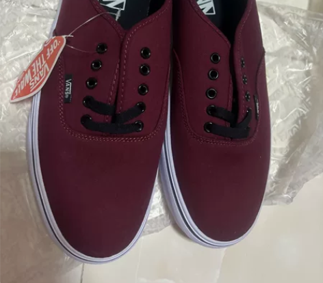 出VANS品牌的帆布鞋，颜色为经典酒红色，...