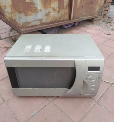 一个旧的海尔牌微波炉。有明显使用，污渍，掉...